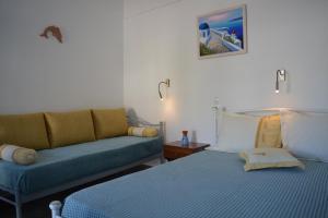 een woonkamer met een bed en een bank bij Klados Studios & Apartments in Cherronisos