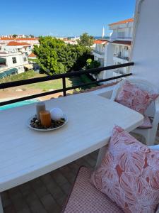 Biały stół z talerzem jedzenia na balkonie w obiekcie Mantamar I w mieście Manta Rota