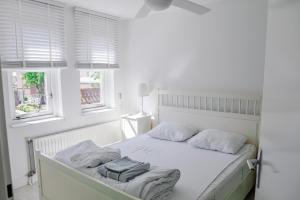 a white bedroom with a white bed with two pillows at Vakantiewoning op het sluisplateau 23 Wemeldinge in Wemeldinge