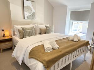 una camera da letto con un grande letto bianco con cuscini sopra di 2 Edward Street a Llandudno