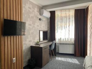 a hotel room with a desk and a television at Hotel Trayana in Stara Zagora