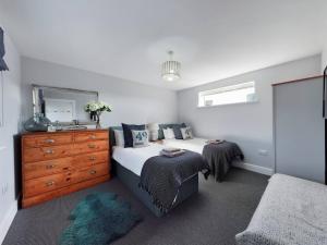 a bedroom with a bed and a dresser and a mirror at Paddlers View - Luxurious 2 bed, hot tub. Town centre, water views in Kingsbridge