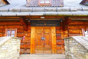 a wooden building with a sign in front of it at Browar POD CZARNYM KOGUTEM in Cieszyn