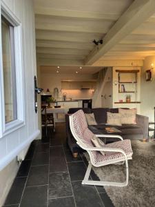 a living room with a couch and two chairs at Honeysuckle Cottage in Longnor