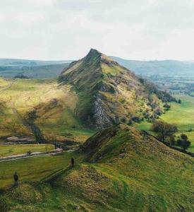 two people standing on top of a hill with a mountain at Honeysuckle Cottage in Longnor