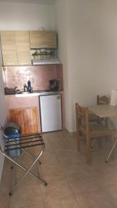 a small kitchen with a table and a table and chairs at Elzahed apartments bonaccia in Kimolos