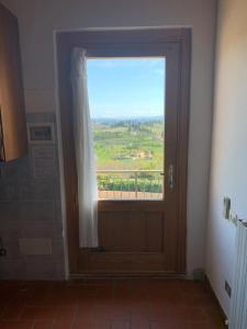 a door with a window in a bathroom with a view at Podere Vigna del Sole in San Gimignano