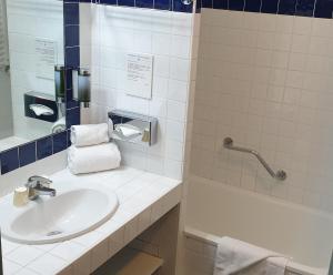 a bathroom with a sink and a tub at Thalacap Île de Ré - Thalasso & Spa in Ars-en-Ré