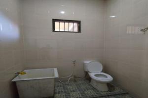 uma casa de banho com um WC, um lavatório e uma janela em SPOT ON 92616 As-sakinah Syariah em Medan