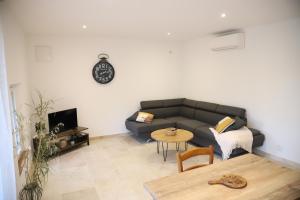 uma sala de estar com um sofá e uma mesa em Duplex de charme au coeur de la Provence. em Pertuis