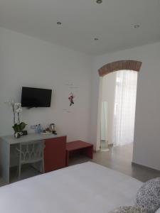 ラ・スペツィアにあるCandy's dream roomsのベッドと机とテレビのある寝室