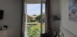 a room with a window with a view of a yard at Thalacap Île de Ré - Thalasso & Spa in Ars-en-Ré
