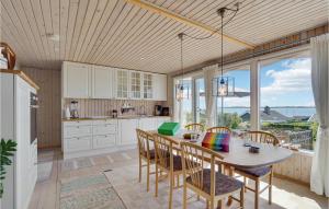 Il comprend une cuisine dotée d'un plafond en bois et d'une table avec des chaises. dans l'établissement Cozy Home In Faaborg With Kitchen, à Fåborg