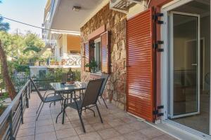 patio con mesa y sillas en el balcón en Bright 2bd apt, garden view & parking - Glyfada, en Atenas