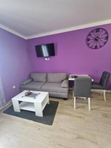 a living room with purple walls and a couch and a table at Apartment Mavero-Free Private Parking in Zagreb