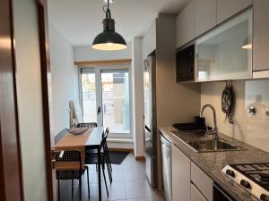 a kitchen with a sink and a table with chairs at Oasis beach apartment in Figueira da Foz