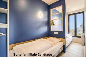 - une chambre dotée d'un lit avec un mur bleu dans l'établissement Résidence LA VAGUE- 4 appartements Grand Confort -Vue mer - 2 à 6 personnes, à Houlgate