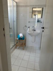 y baño blanco con lavabo y ducha. en Seaclusion Vacation Villa, en Pomos