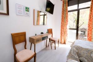 a bedroom with a bed and a desk and a window at Hostal Ramos in Barcelona
