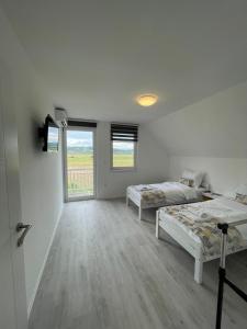 Cette chambre blanche dispose de deux lits et d'une fenêtre. dans l'établissement Guest House Green Field, à Sarajevo