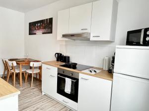 a kitchen with a white refrigerator and a table at Design Apartment - Kingsize Bett - Küche - Zentral in Hannover