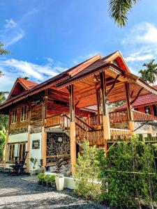 een groot houten huis met een groot terras bij Avita Pool Villa in Sichon