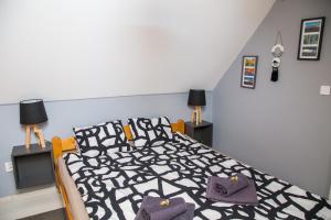 1 dormitorio con 1 cama con edredón blanco y negro en Naphoz Holddal, en Kisapáti