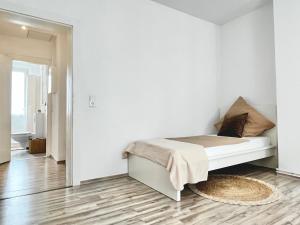 a white bedroom with a bed and a rug at Design Apartment - Kingsize Bett - Küche - Zentral in Hannover