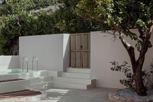Agia Fotini的住宿－Lotusland, a relaxing house at Amari Rethymno，白色的墙壁,有楼梯,窗户和树