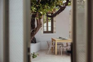 a table and chairs in a room with a tree at Lotusland, a relaxing house at Amari Rethymno in Agia Fotini