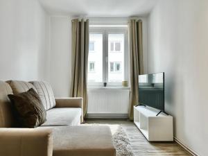 a living room with a couch and a window at Design Apartment - Kingsize Bett - Küche - Zentral in Hannover