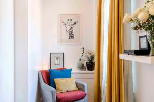 a living room with a chair with colorful pillows at Camden Town Duplex in London