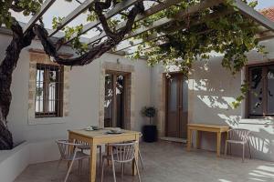 Agia Fotini的住宿－Lotusland, a relaxing house at Amari Rethymno，树下带桌椅的天井