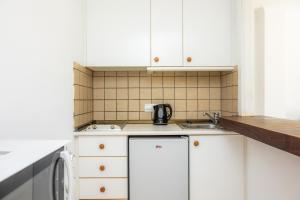 a small kitchen with white cabinets and a sink at Apartament Massanet bb in Canyamel