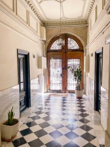 a lobby with a checkered floor and a large door at Hostal Ramos in Barcelona