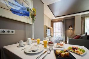 una mesa de comedor con comida y bebidas. en Nexus Valladolid Suites & Hotel, en Valladolid