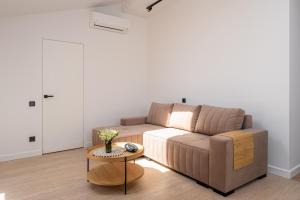 a living room with a brown couch and a table at New flat with free underground parking and air conditioning in Rīga