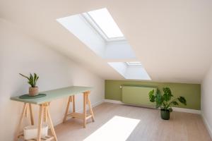 a room with a table and a skylight at New flat with free underground parking and air conditioning in Rīga