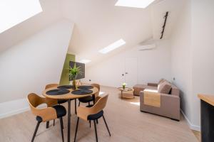 a living room with a table and chairs and a couch at New flat with free underground parking and air conditioning in Rīga