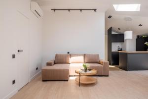 a living room with a couch and a table at New flat with free underground parking and air conditioning in Rīga