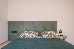 a bedroom with a bed with two pillows on it at New flat with free underground parking and air conditioning in Rīga
