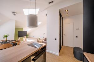 a kitchen and living room with a desk and a dining room at New flat with free underground parking and air conditioning in Rīga