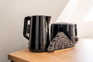 two coffee pots sitting on top of a wooden table at New flat with free underground parking and air conditioning in Rīga