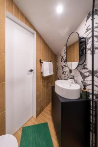 a bathroom with a white sink and a mirror at New flat with free underground parking and air conditioning in Rīga +37 photos