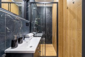 a bathroom with a sink and a shower at New flat with free underground parking and air conditioning in Rīga