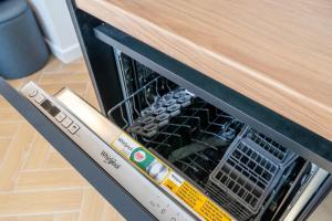 a dishwasher with its door open with food inside at New flat with free underground parking and air conditioning in Rīga