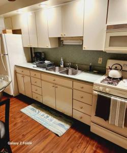 a kitchen with white cabinets and a sink and a stove at Cozy 1 Bedroom Business Suite in Philadelphia +16 photos