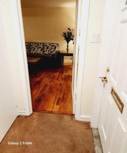 um corredor com uma porta aberta para um quarto com pisos de madeira em Cozy 1 Bedroom Business Suite em Filadélfia