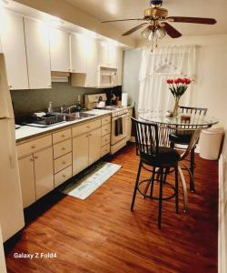 een keuken met een tafel en stoelen en een keuken met witte kasten bij Cozy 1 Bedroom Business Suite in Philadelphia
