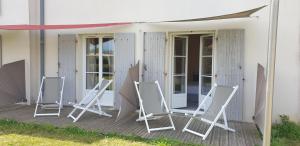 three folding chairs sitting on a porch of a house at Thalacap Île de Ré - Thalasso & Spa in Ars-en-Ré